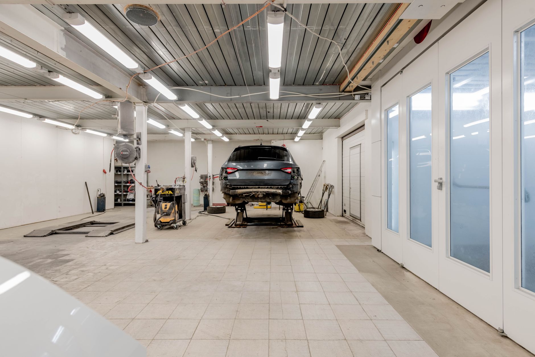 Auto body workshop with a vehicle on a lift ready for repair