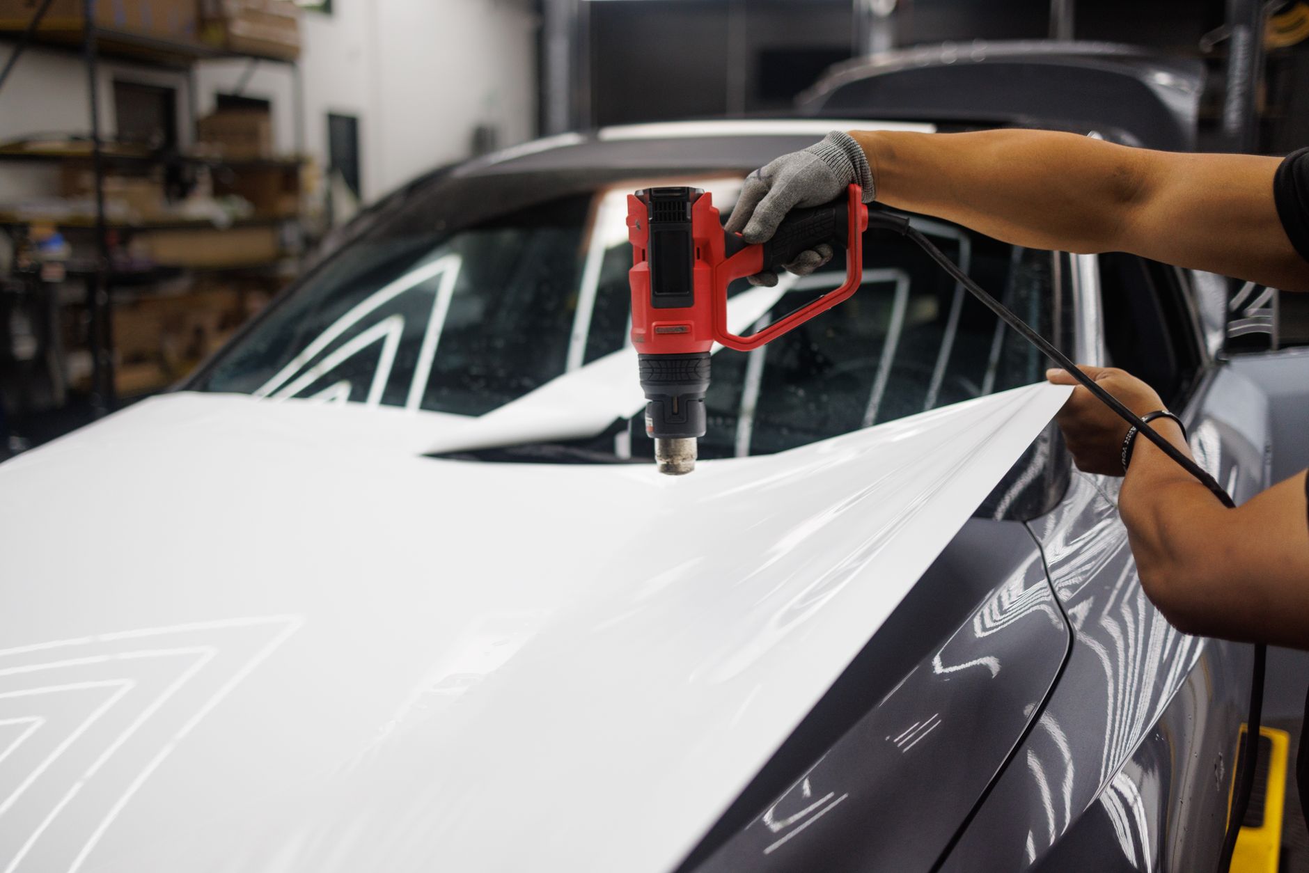 Worker applying a vehicle wrap with a heat gun