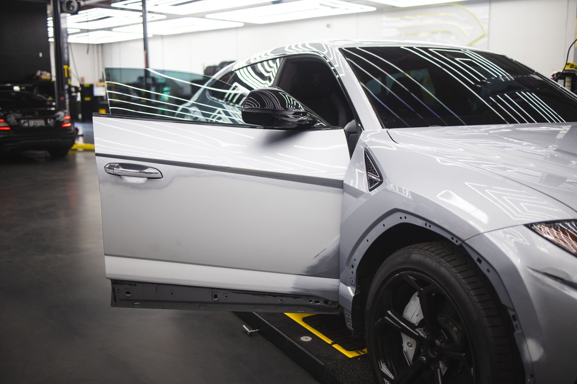 Vehicle with a glossy finish inside a bright auto workshop